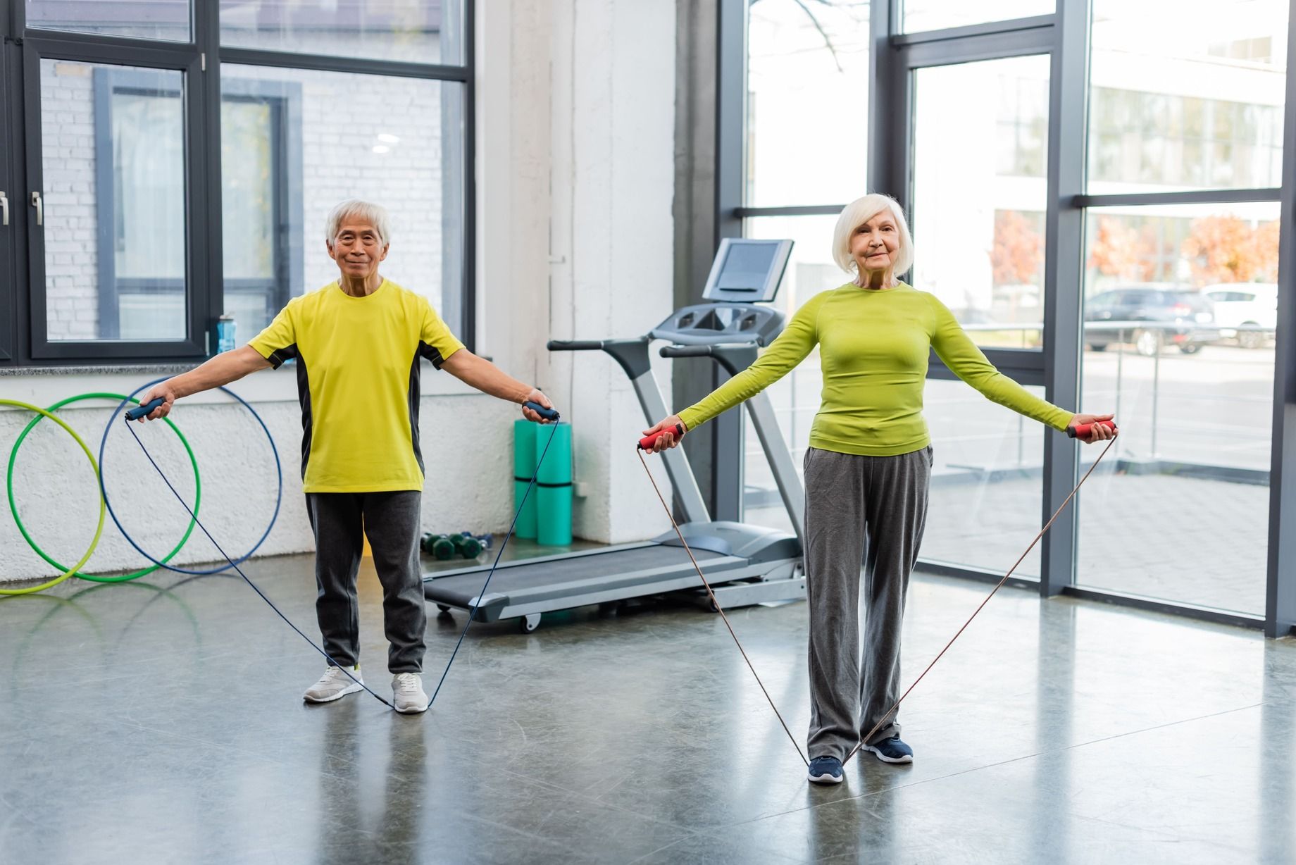 dos ancianos haciendo ejercicio en centro deportivo