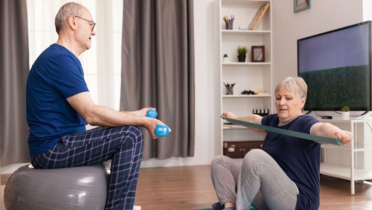 pareja de ancianos haciendo ejercicio en casa